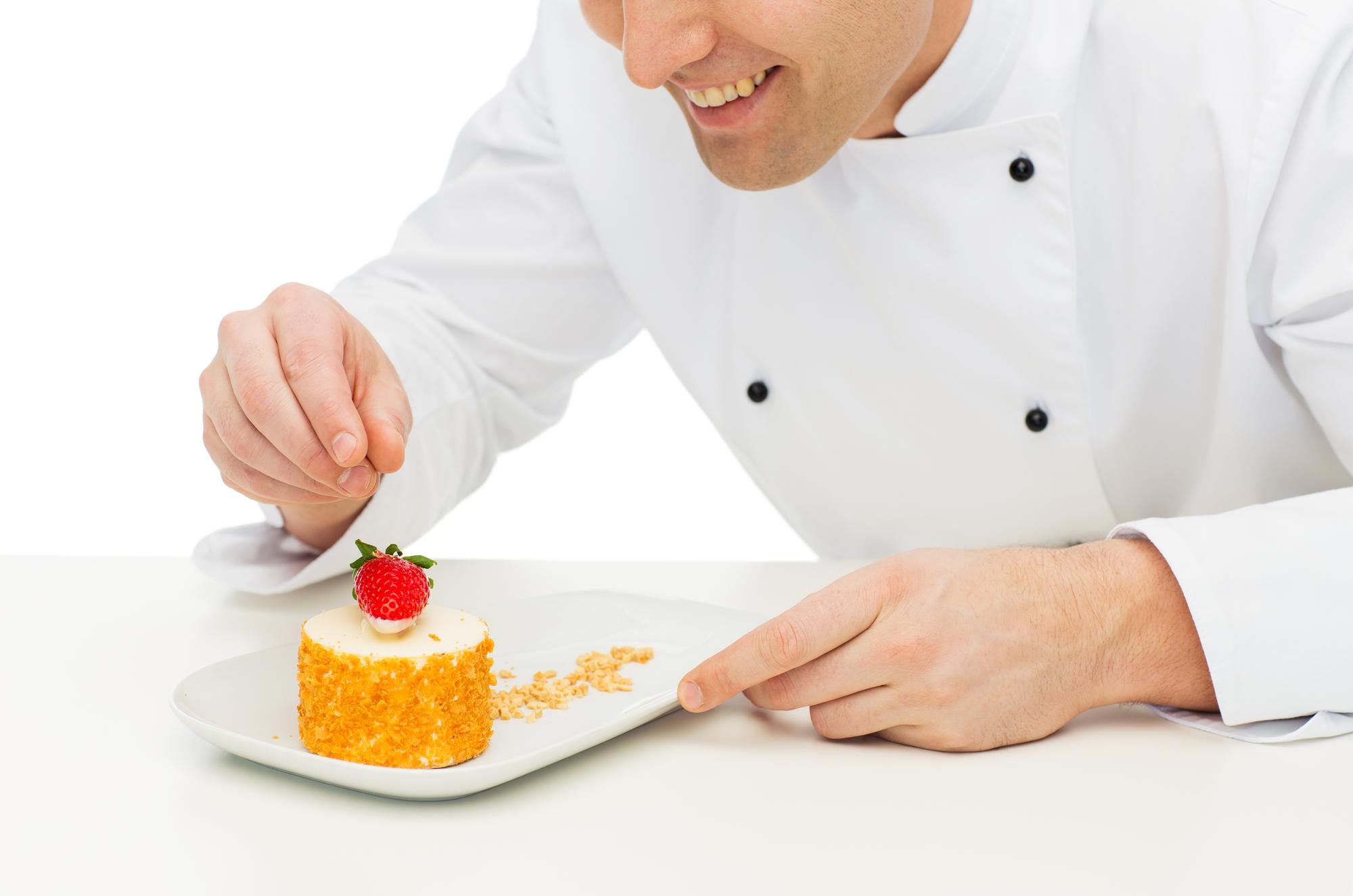 Student plating a dessert under chef guidance